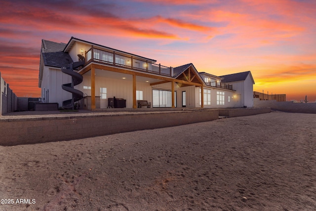 back house at dusk featuring a balcony