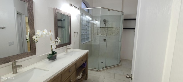 bathroom with a shower stall, tile patterned floors, double vanity, and a sink