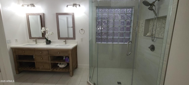 bathroom featuring a shower stall, tile patterned floors, double vanity, and a sink