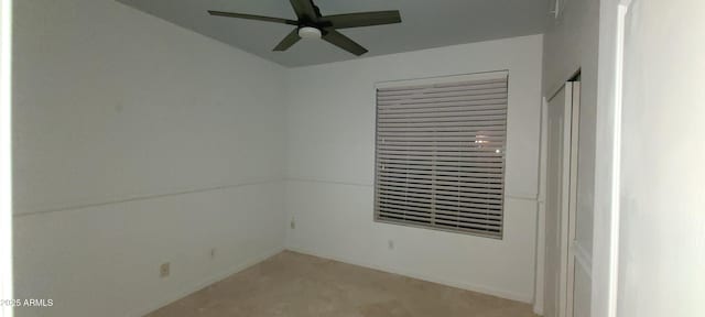 unfurnished room with a ceiling fan and light carpet