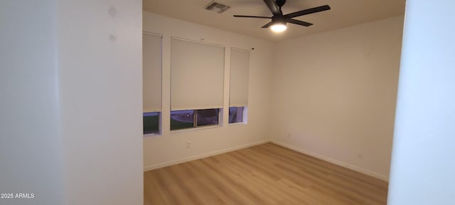 spare room with visible vents, baseboards, a ceiling fan, and wood finished floors