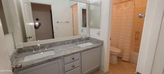 full bath featuring tile patterned flooring, double vanity, a sink, and toilet