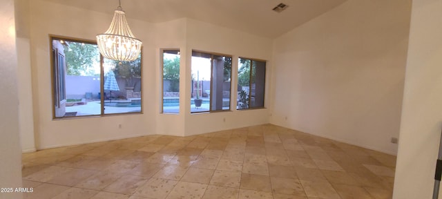 spare room with visible vents, an inviting chandelier, vaulted ceiling, and tile patterned flooring