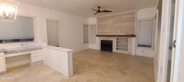 interior space with built in study area, light tile patterned floors, a peninsula, white cabinetry, and a ceiling fan