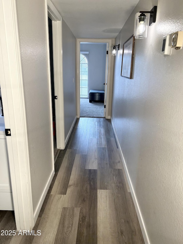 hall with dark wood finished floors and baseboards