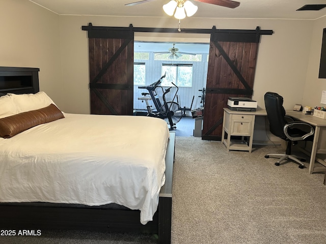 carpeted bedroom with visible vents, ceiling fan, and a barn door