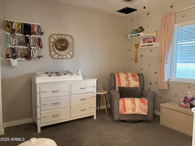 living area featuring dark colored carpet and baseboards