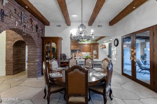 dining area featuring beamed ceiling, french doors, and a chandelier