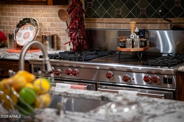 interior details featuring high end stove and tasteful backsplash