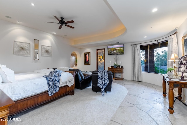 bedroom with a tray ceiling and ceiling fan