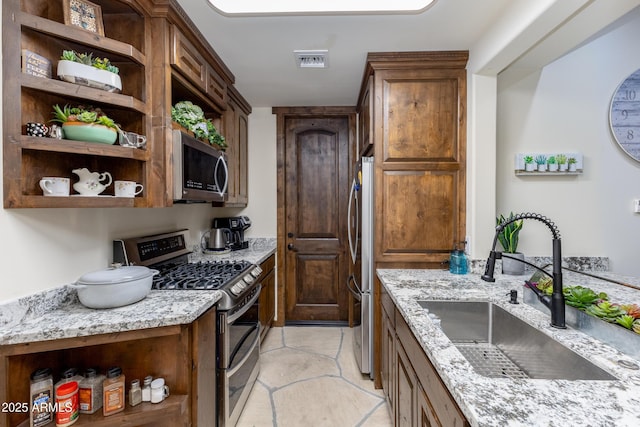 kitchen featuring light stone countertops, sink, and appliances with stainless steel finishes