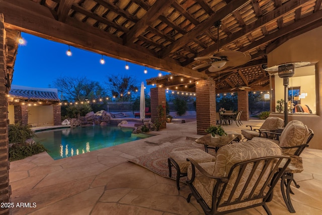 patio at twilight with ceiling fan and a swimming pool with hot tub