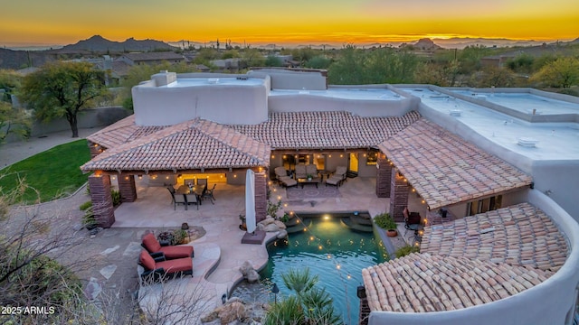 pool at dusk featuring an outdoor living space