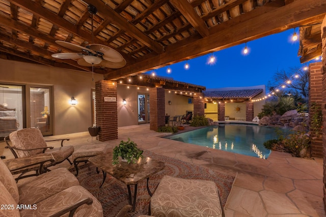 pool at twilight featuring a patio area and ceiling fan