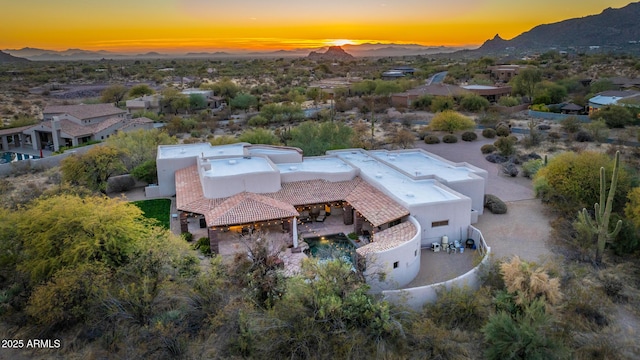 aerial view at dusk featuring a mountain view