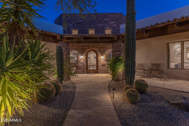 view of exterior entry at twilight