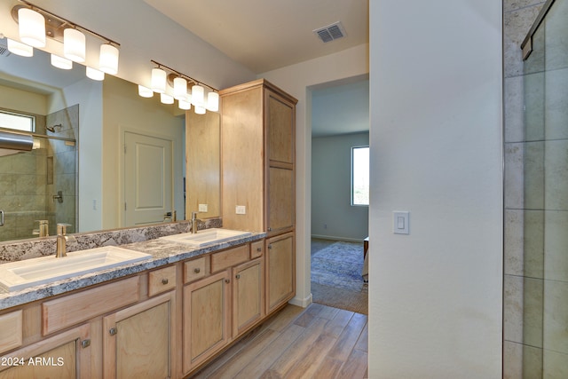 bathroom featuring vanity, hardwood / wood-style flooring, and a shower with shower door