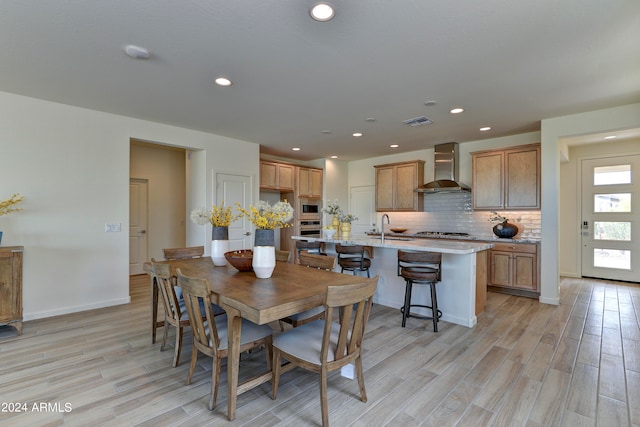 dining area with sink and light hardwood / wood-style floors