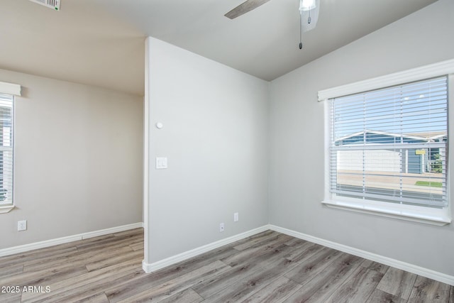 empty room with ceiling fan, baseboards, and wood finished floors