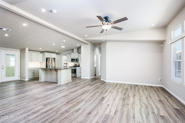 kitchen with vaulted ceiling with beams, visible vents, appliances with stainless steel finishes, and open floor plan