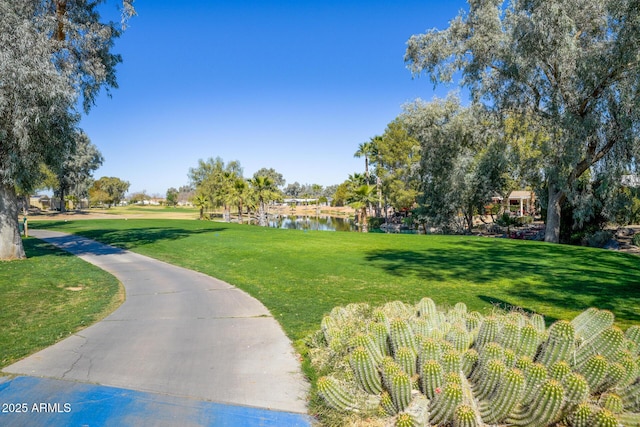 view of property's community featuring a lawn and a water view