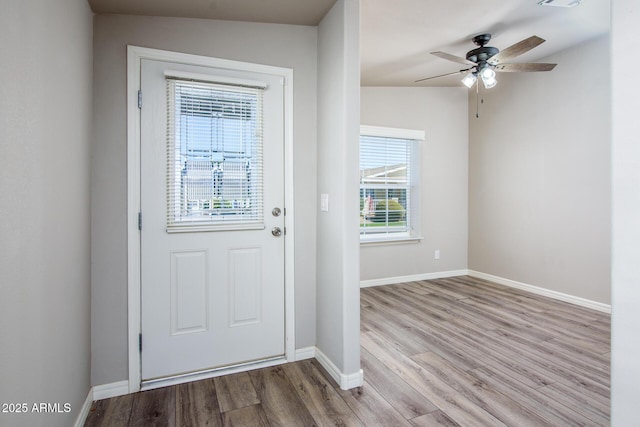 entryway with ceiling fan, visible vents, baseboards, and wood finished floors