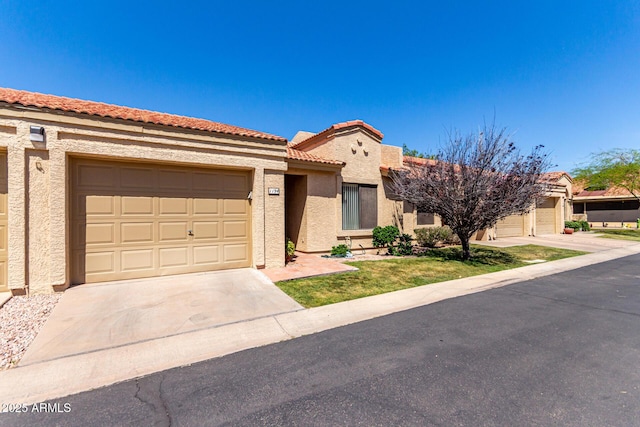 view of front of home featuring a tiled roof, concrete driveway, stucco siding, and a garage