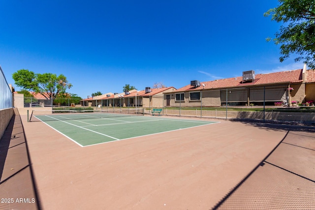 view of sport court with a residential view and fence