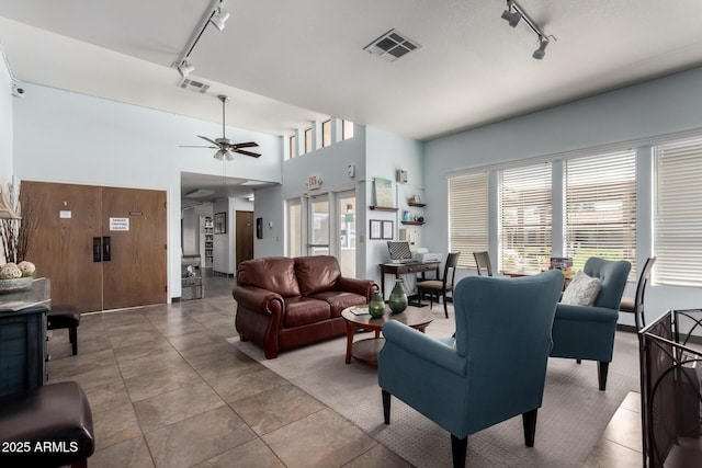 living room featuring track lighting, ceiling fan, and visible vents
