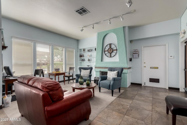 living area with rail lighting, baseboards, built in shelves, and visible vents