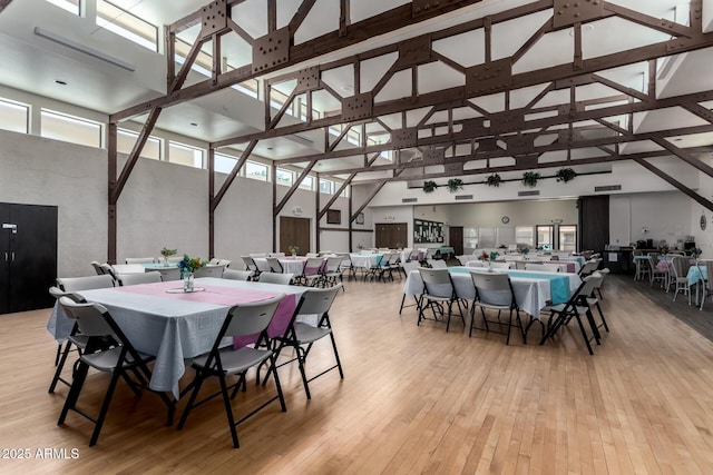 dining room with high vaulted ceiling, light wood finished floors, and beamed ceiling