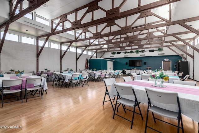 dining space featuring a towering ceiling and hardwood / wood-style flooring