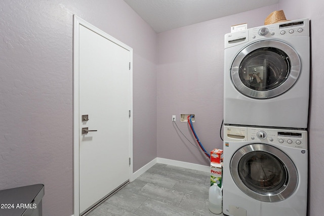 clothes washing area with stacked washer and dryer