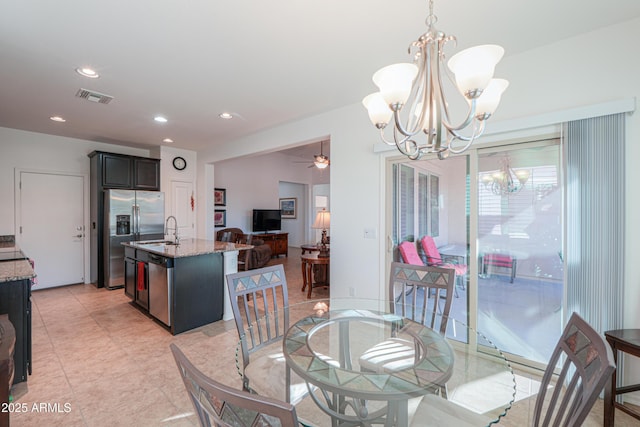 dining area with sink and ceiling fan with notable chandelier