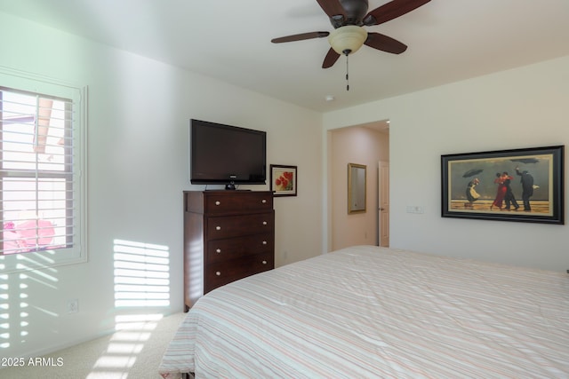 bedroom with ceiling fan, light colored carpet, and multiple windows