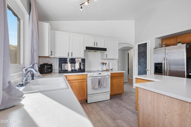 kitchen with white cabinetry, sink, stainless steel fridge with ice dispenser, lofted ceiling, and white stove