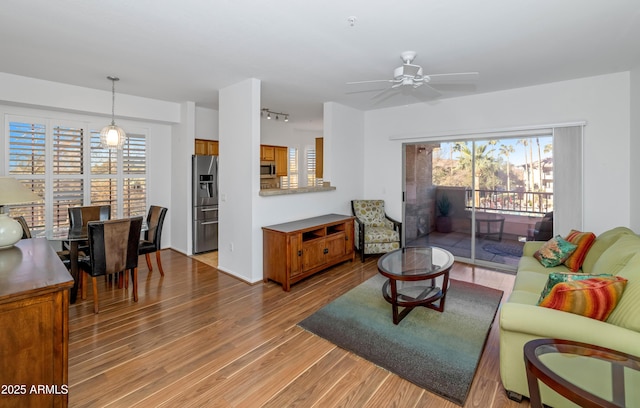 living room featuring ceiling fan and hardwood / wood-style flooring