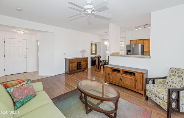 living room featuring ceiling fan and light hardwood / wood-style floors