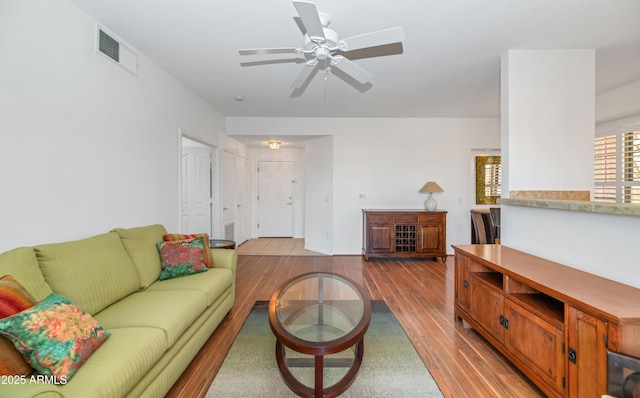 living room with ceiling fan and light hardwood / wood-style flooring