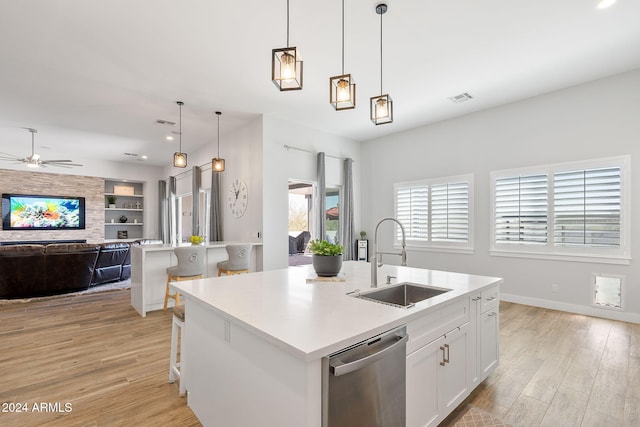 kitchen featuring dishwasher, sink, white cabinetry, and an island with sink