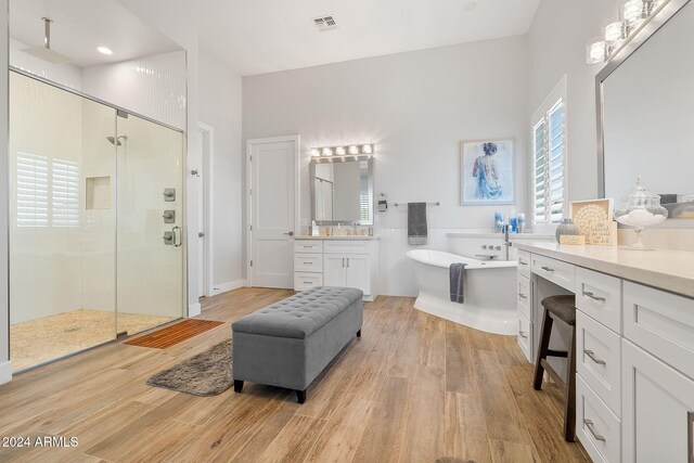 8523 N 192nd Ave, Waddell, AZ 85355 - full bathroom with a stall shower, a freestanding tub, wood finished floors, vanity, and a towering ceiling