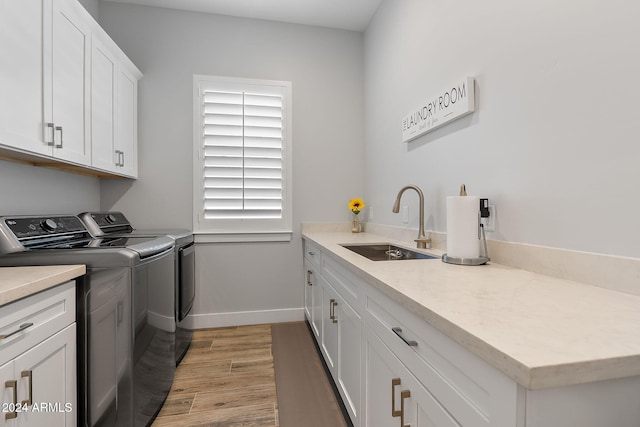 washroom with washer and dryer, light hardwood / wood-style floors, cabinets, and sink