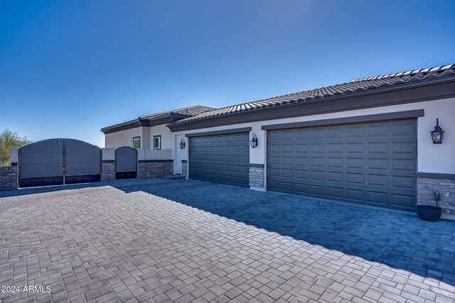 8523 N 192nd Ave, Waddell, AZ 85355 - ranch-style house featuring stone siding, a gate, stucco siding, and decorative driveway