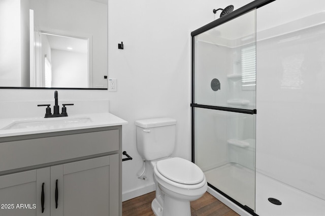 bathroom featuring vanity, toilet, an enclosed shower, and hardwood / wood-style floors