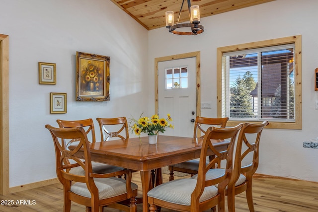 dining space featuring a notable chandelier, wood ceiling, and light hardwood / wood-style flooring