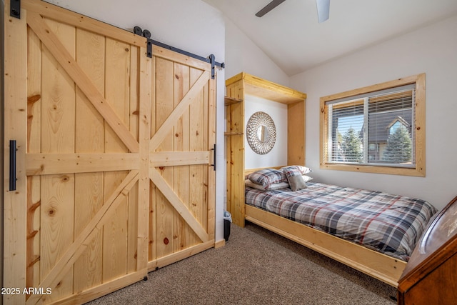 carpeted bedroom with lofted ceiling, a barn door, and ceiling fan