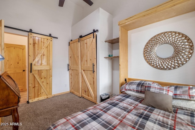 bedroom with carpet floors, a barn door, and ceiling fan