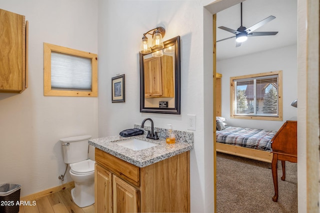 bathroom with ceiling fan, vanity, toilet, and hardwood / wood-style floors