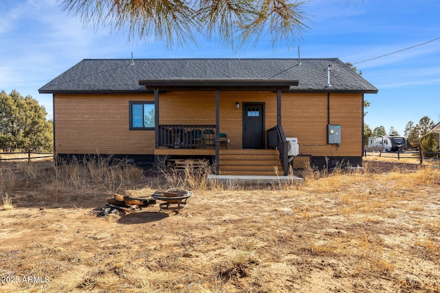 rear view of house with a porch and an outdoor fire pit