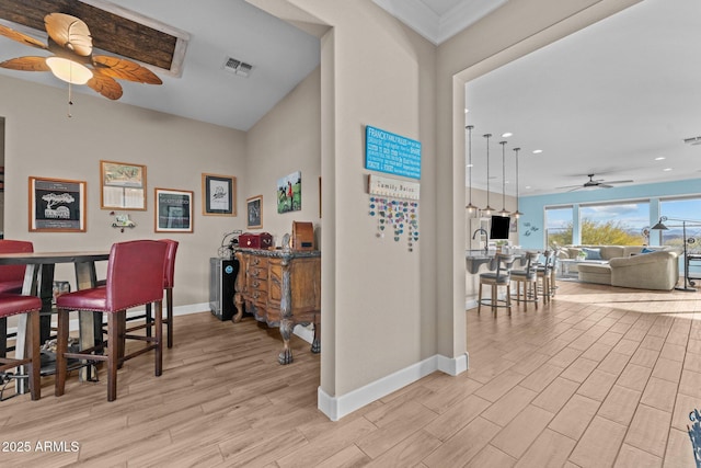 dining room with crown molding, ceiling fan, and light hardwood / wood-style floors